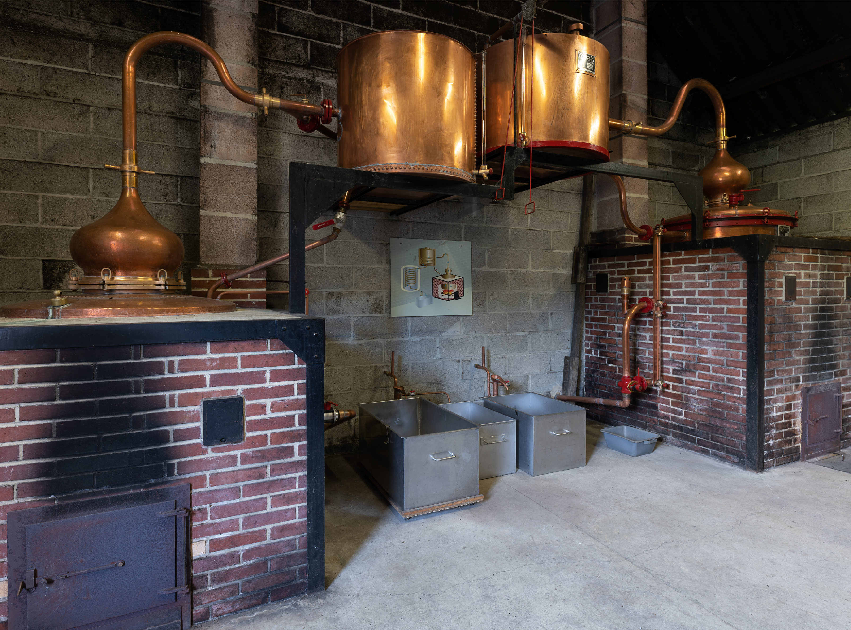 Traditionelle Kupferbrennblasen in einer normannischen Calvados-Brennerei aus Backstein