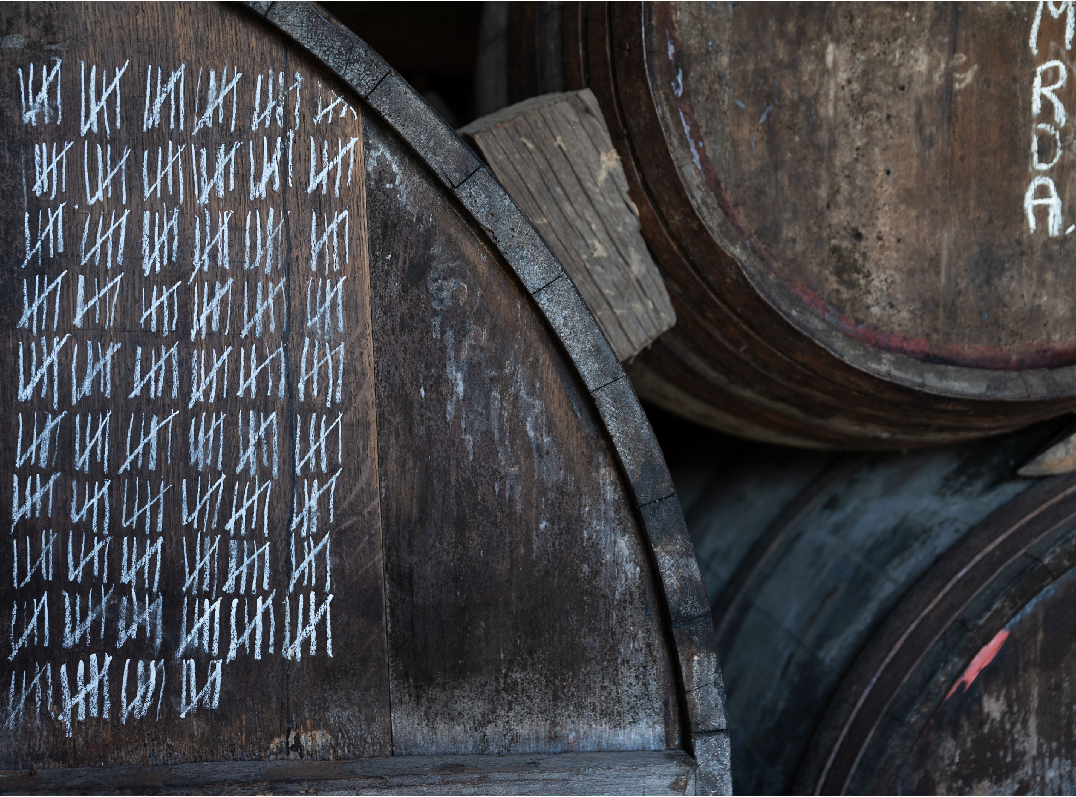 Eichenfässer zur Calvados-Reifung, mit Kreidemarkierungen für Jahrgang und Alter