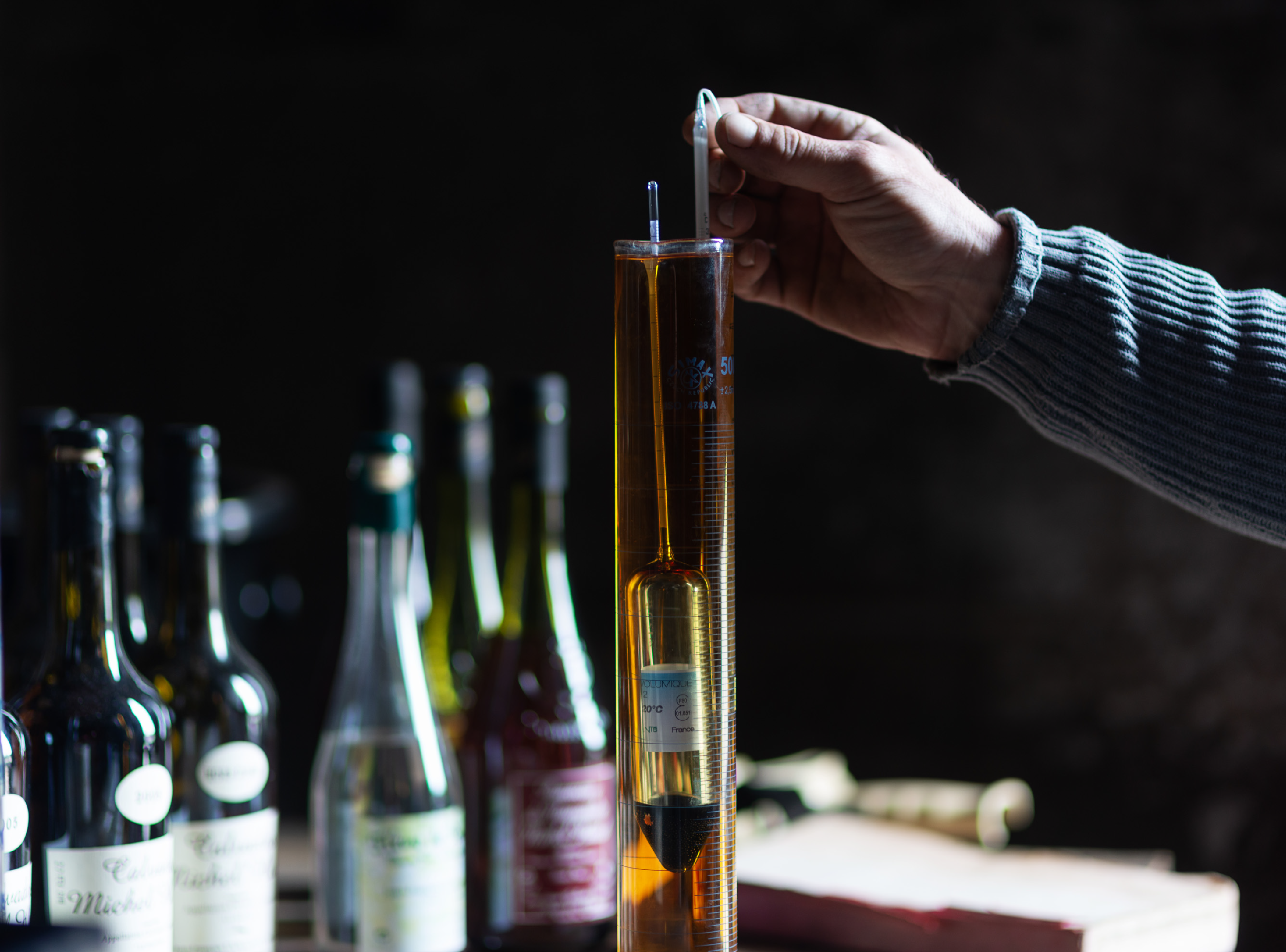 Qualitätskontrolle: Calvados-Probe im Reagenzglas, Alkoholgehalt wird mit einem Messgerät geprüft